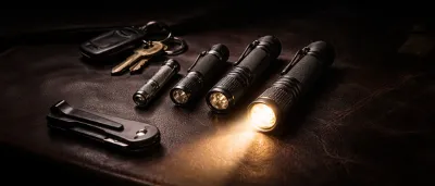 Kompakte EDC-Taschenlampen für die Hosentasche auf dunklem Untergrund